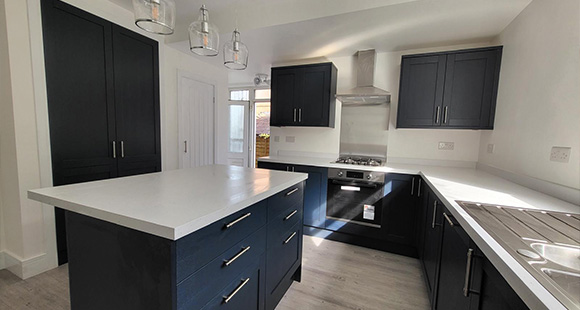 modern kitchen design with dark cabinetry and white countertop featuring an island and stainless steel appliances perfect for cooking and entertaining two different color tones